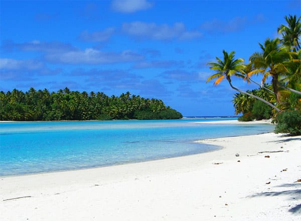 One Foot Island/Aitutaki Atoll, Cookinseln: Idyllischer geht es kaum: Saftig grüne Palmen säumen den flach abfallenden Traumstrand von One Foot Island