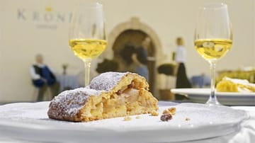 Südtirol vereint verschiedene kulinarische Traditionen: Zu einem guten Glas Wein schmeckt auch ein Stück Apfelstrudel.