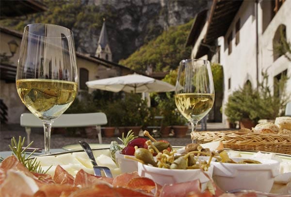 Ein Glas Südtiroler Weißwein harmoniert gut mit Antipasti oder Speck aus regionaler Erzeugung.