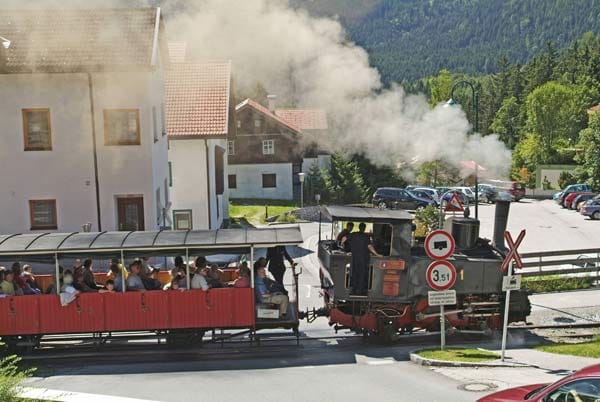 Seit 1889 kämpfen sich die ältesten Dampf-Zahnradlokomotiven der Welt, die Achsenseebahn fauchend und zischend die 6,76 Kilometer hinauf vom unteren Inntal zum Achensee in Tirol. 440 Höhenmeter mit einer maximalen Steigung von 160 Promille legt die glänzende schwarze Lok mit den blankpolierten roten Waggons zurück.