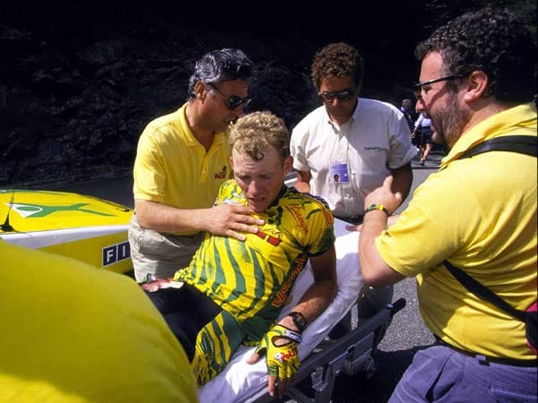 Einer der tragischsten Stürze in der Tour-Historie ereignet sich 1995 während der 15. Etappe. Auf der Abfahrt des Portet-d'Aspet kommt es zu einem Massensturz, der für den Italiener Fabio Casartelli nach einem Aufschlag mit dem Kopf auf einer Straßenbegrenzung aus Beton tödlich endet. Der Deutsche Dirk Baldinger (im Bild) wird mit Beckenbruch ins Krankenhaus geliefert.