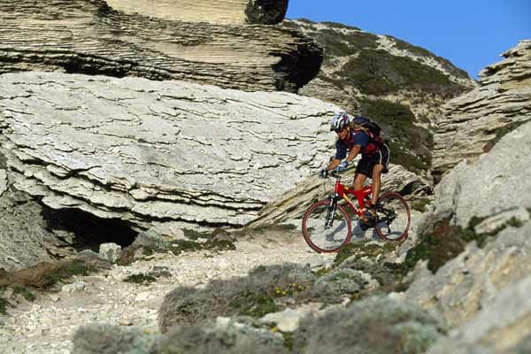 Korsika: Mountainbiker in den Felsen.