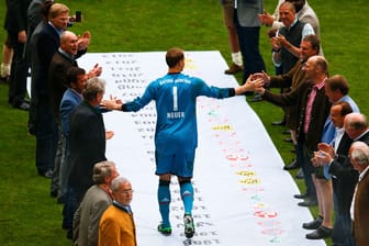 Manuel Neuer empfängt auf dem Weg zur Siegerehrung die Glückwünsche der versammelten Legenden des FC Bayern.