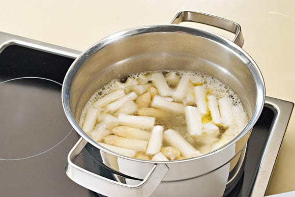 Spargelsuppe zubereiten: Gießen Sie Brühe dazu und fügen Sie 25 Gramm Butter und Zucker bei. Bringen Sie das Ganze zum Kochen und garen Sie die Spargelstücke auf kleiner Flamme 15 bis 20 Minuten lang bissfest.