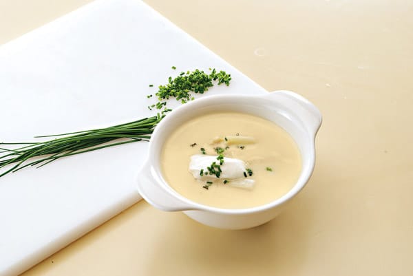 Spargelsuppe zubereiten: Schmecken Sie die Suppe mit Salz, Pfeffer, Muskat und Zitronensaft ab und servieren Sie sie mit aufgeschlagener Sahne und Schnittlauch.