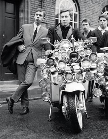Die jungen Mods kleideten sich in den frühen 1960ern gerne in Anzügen und Parkas und fuhren so auf ihren Scootern durch die Gegend.