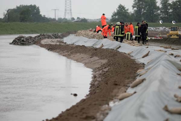 In Südhessen droht ein Rheinzufluss Teile der Stadt Biblis zu überschwemmen. In der Nacht zu Samstag stockten Feuerwehrleute einen Damm auf.