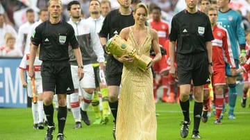 Kickbox-Weltmeisterin Dr. Christine Theiss trägt den Pokal ins Olympiastadion. Insgeheim wird die athletische Schönheit dem Rekordmeister die Daumen drücken - denn sie ist Bayern-Fan.