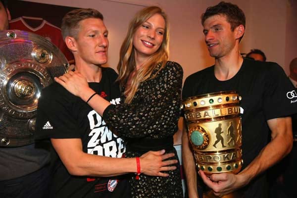Dort darf Bastian Schweinsteiger endlich seine Sarah in den Arm nehmen. Thomas Müller vergnügt sich mit dem Pott.