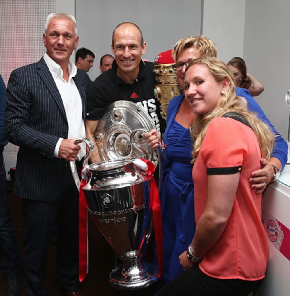 Arjen Robben hat sich die drei Pokale kurzerhand für ein Familienfoto ausgeliehen.