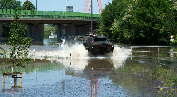 In Niederwartha bei Dresden fährt die Bundeswehr mit einem Panzerwagen durch die Fluten.