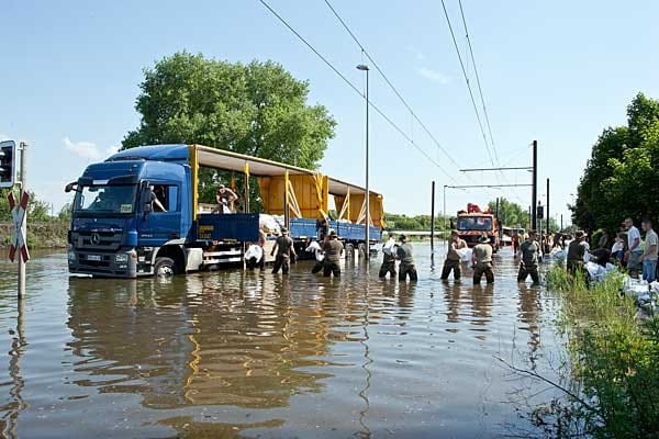 Private Hilfe: Ein Spediteur fuhr seinen für den Fernverkehr ausgelegten Sattelzug mit Sandsäcken durch den immer höher steigenden Wasserstrom auf dem Magdeburger August-Bebel-Damm.