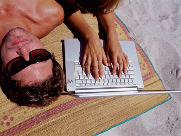 Mann und Frau beim Sonnenbad mit Laptop