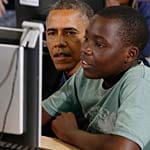 Im "HIV Youth Center" von Kapstadt, einer Einrichtung von Bischof Desmond Tutu, schaut Obama einem Jungen am Computer über die Schulter.