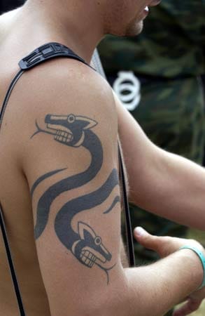 Ein Mann, der ein Schlangen-Tattoo trägt, lässt sich mit folgenden Worten beschreiben: Große Klappe und nichts dahinter.