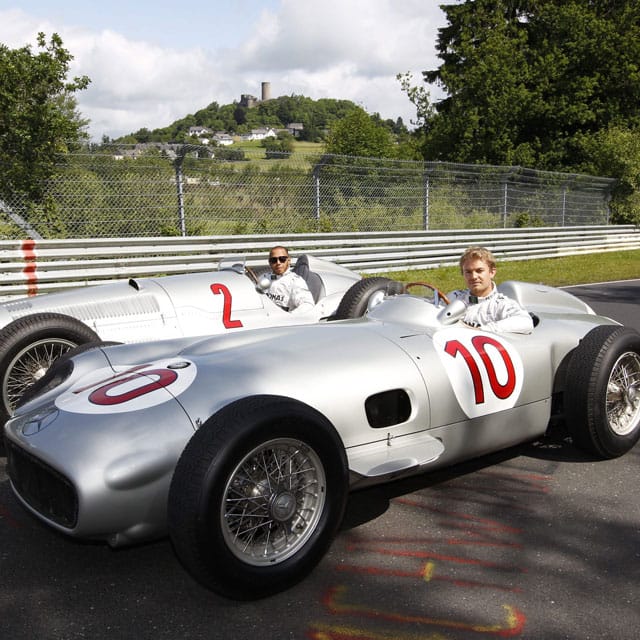 Nico Rosberg (vorne) und Lewis Hamilton in den historischen Silberpfeilen - im Hintergrund ist die Nürburg zu sehen.