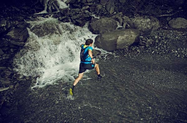 Trail Running: Queren eines Bachlaufs.