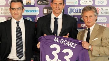 Der Sportdirektor vom AC Florenz Daniele Prade (re.) begrüßt Mario Gomez auf seiner ersten Pressekonferenz in Italien