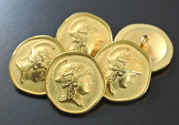 Ein Gegensatz zu Fake-Knöpfen auf Stangenware: Dieser Goldknopf wirkt wie eine uralte Münze und zeigt den Kopf des griechischen Gottes Hermes.