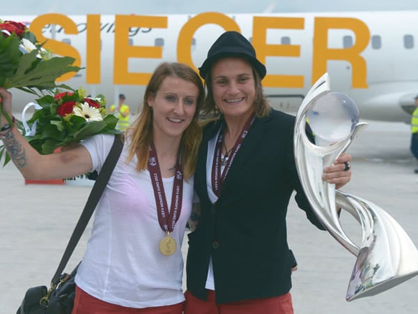 Die Matchwinnerinnen des Finales Anja Mittag (li.) und Nadine Angerer präsentieren die Trophäe kurz nach der Ankunft in der Heimat am Frankfurter Flughafen.