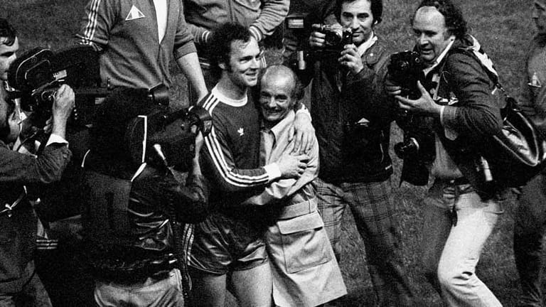 Nach der (ersten) Ära Lattek bei Bayern gelingt national zunächst nicht allzu viel, dafür umso mehr auf europäischer Ebene. 1975 verteidigt der FCB den Titel im Europokal der Landesmeister (2:0 im Finale gegen Leeds United) und der Kaiser herzt seinen Trainer Dettmar Cramer.