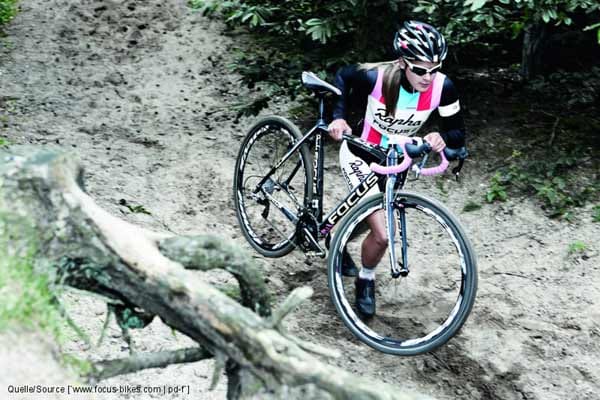Cyclocross: Bikerin trägt ihr Rennrad.