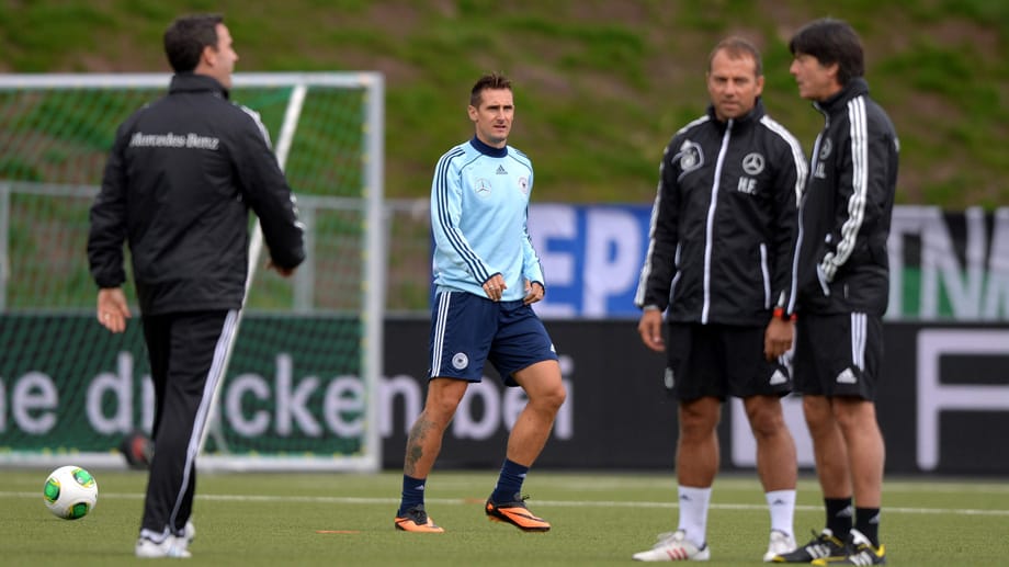 Jogi Löw und Hansi Flick beraten sich, während Miroslav Klose trainiert.