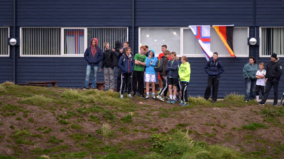 Einstimmung aufs WM-Qualifikationsspiel: Während diese Jugendlichen den Deutschen beim Training gespannt zusehen, wehen im Hintergrund schon die deutsche Flagge und die der Färöer im Wind.