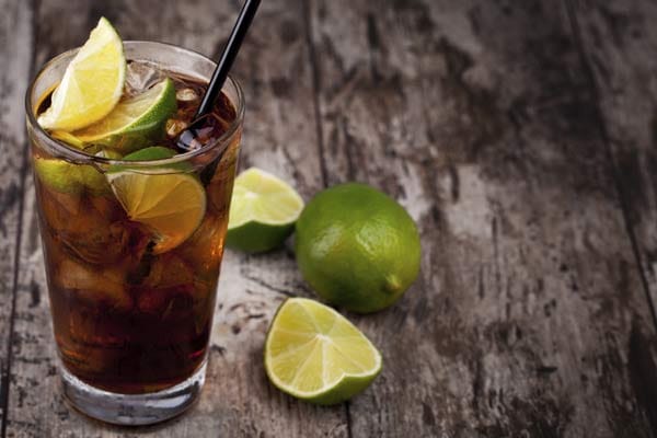 Einer der beliebtesten Klassiker ist der Cuba Libre. Dafür brauchen Sie Weißen Rum, Limetten, Cola und Crushed Ice.