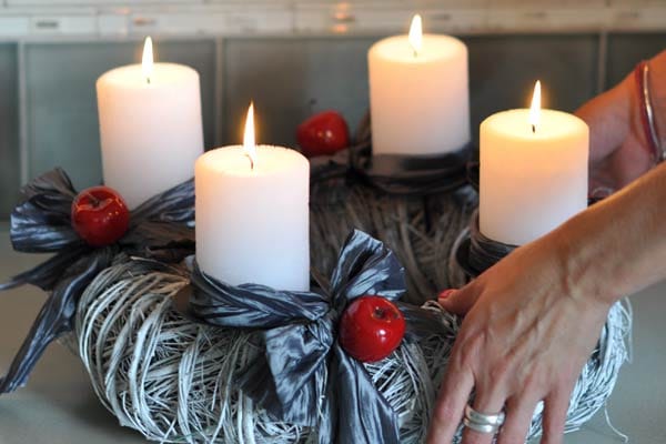 Moderne Adventkränze: Weiße Kerzen auf Birkenstamm-Stücken mit schwarzen Bändern