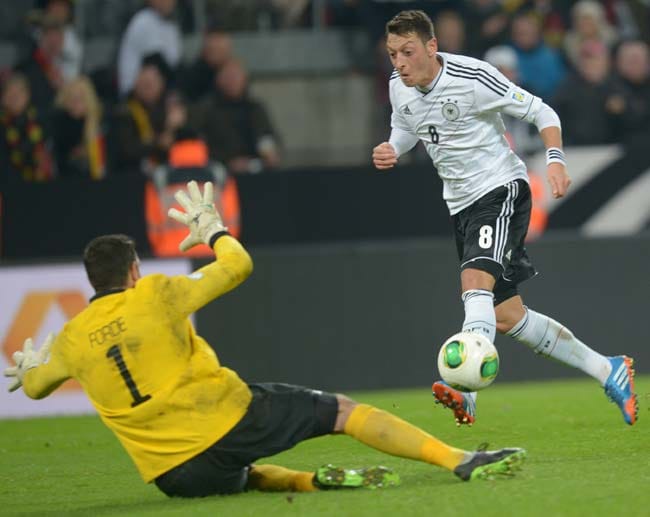 Özil (re.) schießt das Tor zum 3:0-Endstand in der Nachspielzeit, Irlands Torhüter David Forde kann den Treffer nicht verhindern. Mit dem ungefährdeten Sieg bucht Deutschland das Ticket für die WM-Endrunde 2014 in Brasilien.