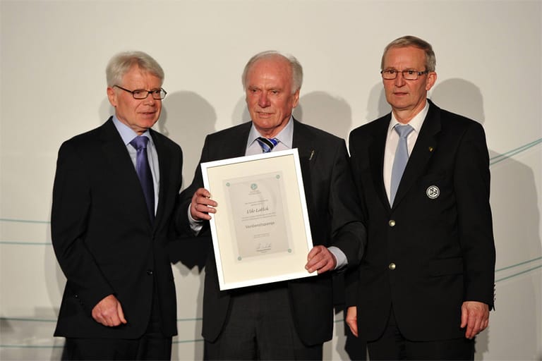 Anfang 2012 erhält Lattek (Mitte) von Ligapräsident Reinhard Rauball (li.) und Rainer Milkoreit (re.), Leiter des DFB-Lehrstabs, die Verdienst-Urkunde für Fußballtrainer des DFB.