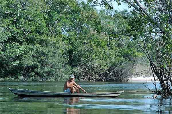 Brasilianer im Einbaum auf den einsamen Nebenarmen des Rio Negro.