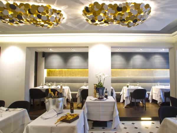 Nach vielen erfolgreichen Jahren in der "Osteria Enoteca" hat sich Carmelo im eigenen Restaurant in Frankfurt Sachsenhausen einen sehr schicken, sehr modernen Salon in Grau mit goldenen Akzenten eingerichtet.