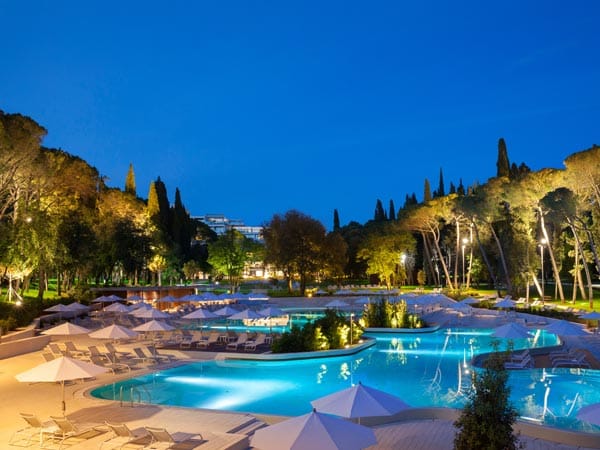 Die große Poollandschaft des Hotels ist von der Natur umgeben und schafft während der Abendbeleuchtung eine besonders romantische Atmosphäre.