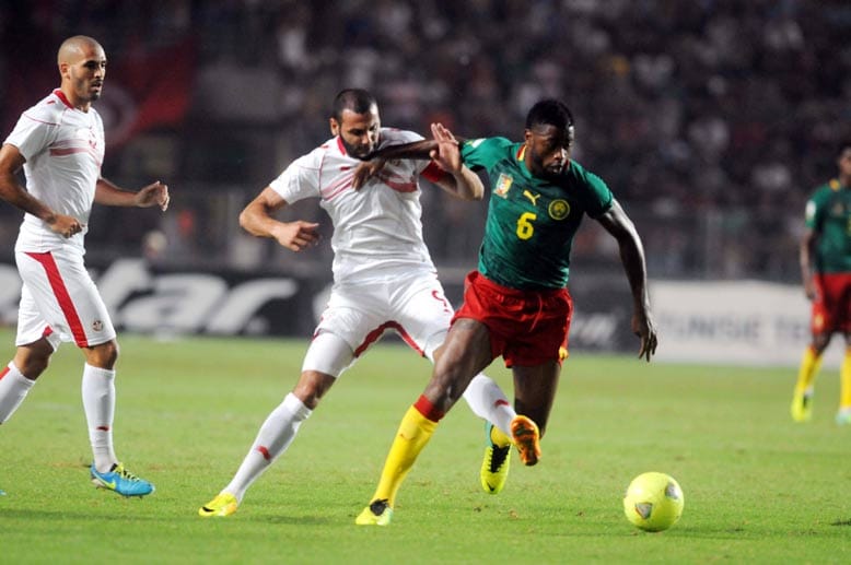 Nur sechs Monate nach seinem Antritt hat der frühere Bundesligatrainer Volker Finke Kamerun verzückt und die Unzähmbaren Löwen zur WM 2014 in Brasilien geführt. Kamerun setzt sich in den entscheidenden Playoff-Spielen gegen Tunesien durch und nimmt insgesamt zum siebten Mal an der Endrunde teil.