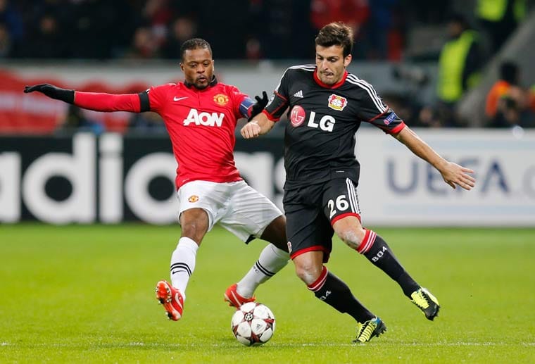 Manchester Uniteds Patrice Evra (li.) attackiert Leverkusens italienischen Rechtsverteidiger Giulio Donati.