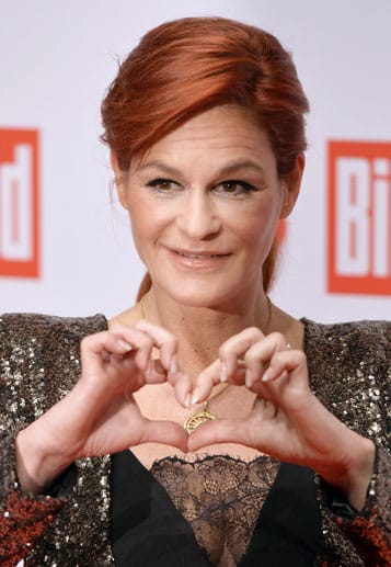 Andrea Berg formt ein Herzchen.
