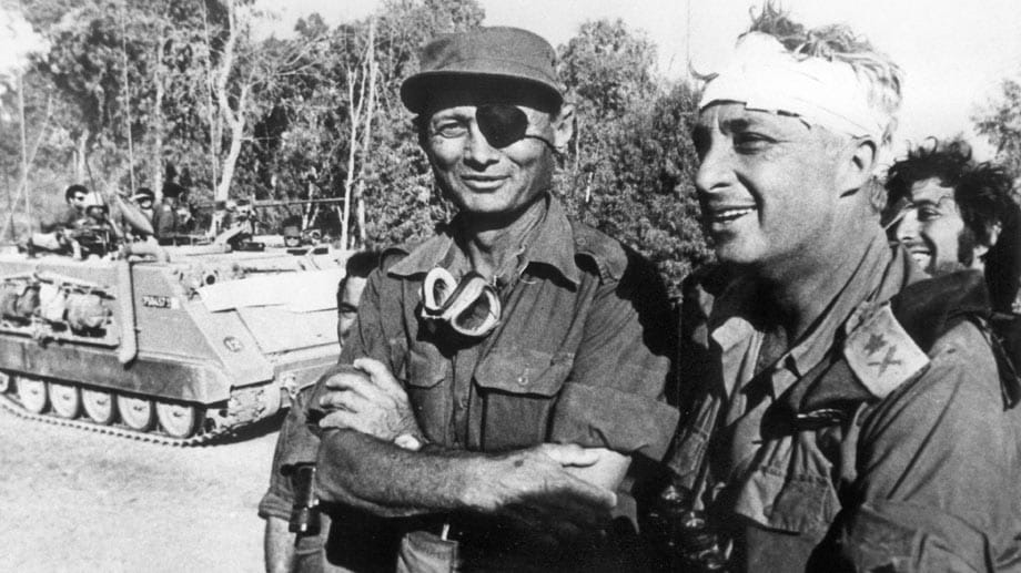Der damalige israelische Verteidigungsminister und General Mosche Dajan (li.) mit Generalmajor Scharon, der einen Kopfverband trägt, aufgenommen auf der ägyptischen Seite des Suezkanals während des Yom-Kippur-Krieges am 18.10.1973. Der damalige israelische Verteidigungsminister und General Mosche Dajan (li.) mit Generalmajor Scharon, der einen Kopfverband trägt, aufgenommen auf der ägyptischen Seite des Suezkanals während des Yom-Kippur-Krieges am 18.10.1973.