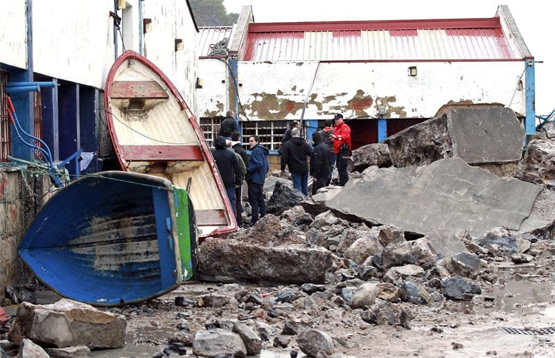 Boote liegen kreuz und quer, viele Gebäude haben Schäden davongetragen: Die Einwohner von Bermeo sehen sich das Ausmaß des Sturms an.