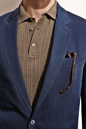Statt einem Hemd greift der modische Gentleman in diesem Frühjahr gerne einmal zum feinen Strick. Das Sakko erstrahlt durch feine Details wie aufwendige Stitchings an den Kanten (Sakko von Tommy Hilfiger Tailored um 330 Euro).