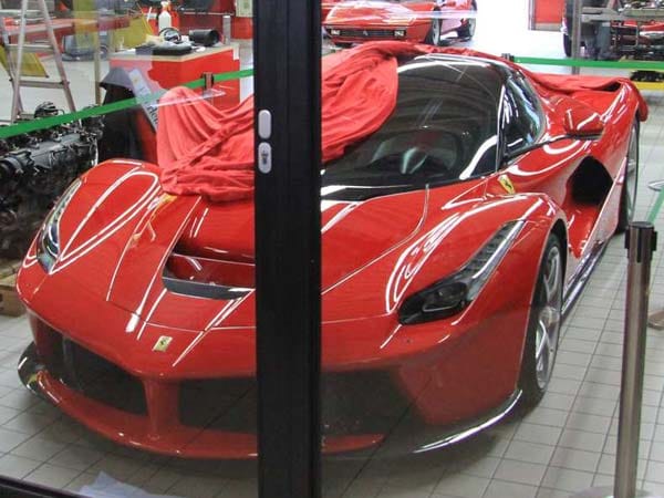 Derzeit parkt sogar ein La Ferrari, einer der ersten überhaupt in Deutschland, von einem roten Tuch bedeckt und einem grünen Absperrband mit der Aufschrift "Hybrid Car Area" umrahmt in der heiligen Werkstatthalle.