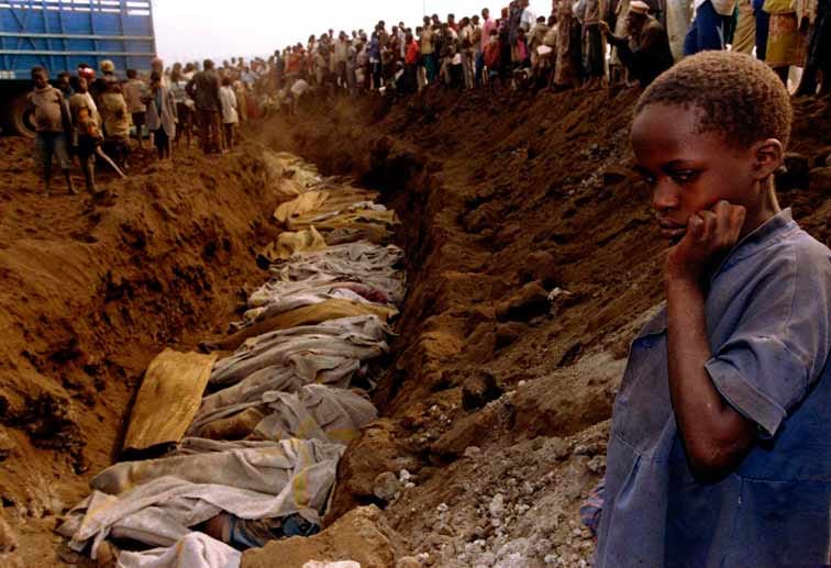 Ein Flüchtlings-Mädchen schaut voller Entsetzen auf ein Tutsi-Massengrab. Das Bild erinnert an die Massenerschießungen der Juden in den besetzten deutschen Gebieten im Zweiten Weltkrieg. Der Ort der Aufnahme ist nicht bekannt - es kann überall im Land sein (20. Juli 1994)