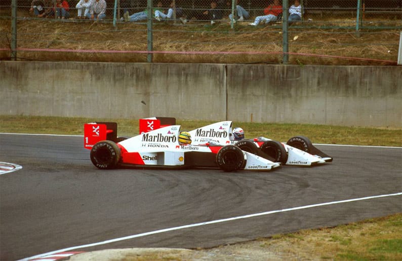 Prost (hinten) und Senna werden nach einem Überholmanöver des Brasilianers in Imola zu Rivalen. Prost war der Meinung, Senna habe sich nicht an eine Teamanweisung gehalten. Die Rivalität gipfelt in diesem Crash beim Großen Preis von Japan 1989. Beim Überholversuch Sennas scheidet Prost aus und der Brasilianer gewinnt das Rennen. Der damalige FIA-Boss Jean-Marie Balestre, ein Landsmann des Franzosen Prost, disqualifiziert Senna im Nachhinein. Senna spricht von Manipulation.