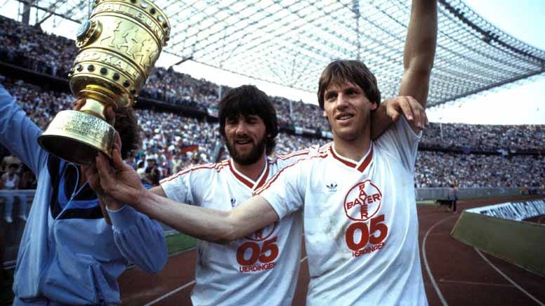 Endspiel 1984/85: Bayer 05 Uerdingen - FC Bayern München 2:1: Das erste, übrigens nicht ausverkaufte, Finale in Berlin hält gleich einen Knaller parat. Außenseiter Uerdingen (hier jubeln Friedhelm, li., und Wolfgang Funkel) bezwingt die Bayern, die Dieter Hoeneß in Führung gebracht hatte, dank der Tore von Horst Feilzer und Wolfgang Schäfer. Bei Schäfers Treffer sind die Münchner nach Rot gegen Wolfgang Dremmler nur noch zu Zehnt.