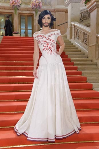 2011 erfand Neuwirth die Kunstfigur Conchita Wurst. In kompletter Conchita-Montur - Damenkleider, starkes Make-up und Vollbart - trat sie fortan in der Öffentlichkeit auf, wie hier im Jahr 2012 beim Wiener Opernball. Die Dragqueen trug ein bodenlanges Kleid in rot und weiß.