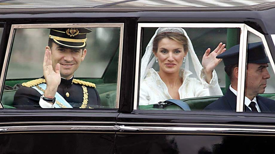 Kronprinz Felipe von Spanien und seine frisch angetraute Braut Letizia winken am 22. Mai 2004 nach der Trauung in der Almudena-Kathedrale in Madrid aus einer gepanzerten Rolls-Royce-Limousine dem Volk zu.