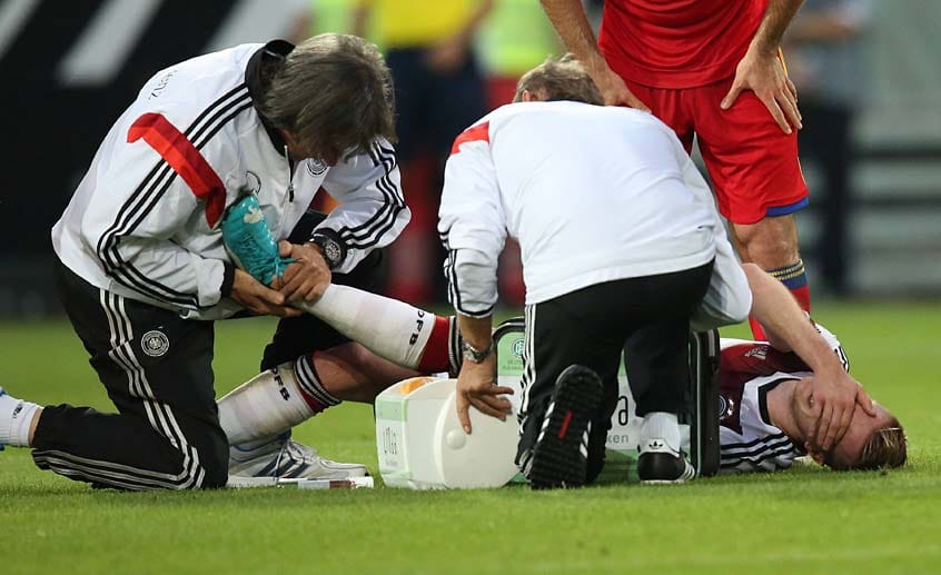 Untersuchung: Der deutsche Team-Arzt Hans-Wilhelm Müller-Wohlfahrt (links) führt Test am verletzten Knöchel von Marco Reus durch, was für den Nationalspieler offensichtlich sehr schmerzhaft ist.