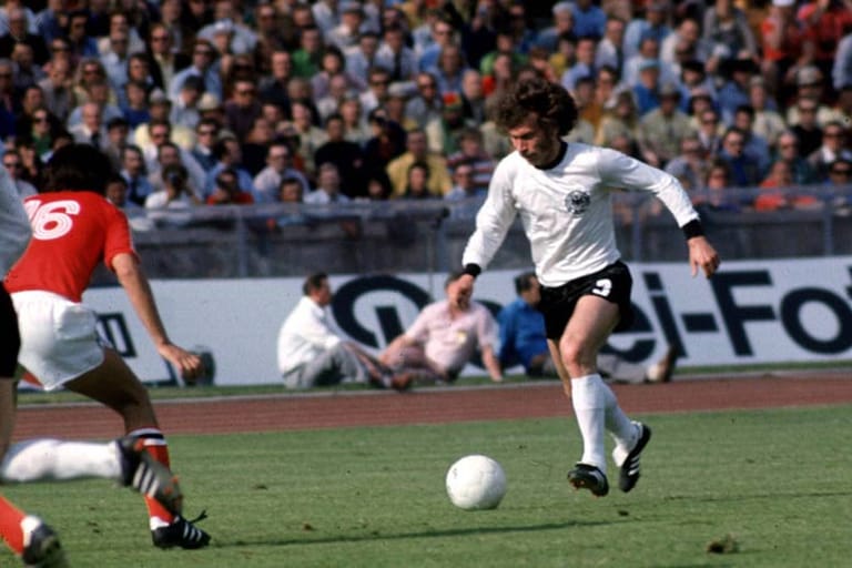 14. Juni 1974 in Berlin - 1:0 gegen Chile: Der Druck des Favoriten lastet beim Start in die Heim-WM schwer auf der deutschen Elf. Ein Gewaltschuss von Paul Breitner (Bild re.) beschert den ersten Sieg, spielerischen Glanz verbreitet das Team auch im weiteren Turnierverlauf nur selten. Am Ende steht dennoch der zweite WM-Titel.