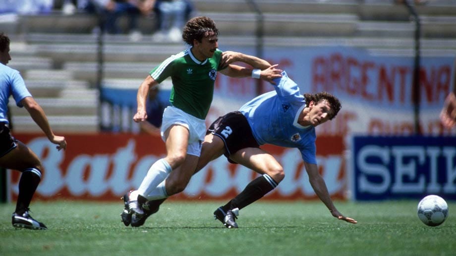 4. Juni 1986 in Queretaro - 1:1 gegen Uruguay: Klaus Allofs (Mi.) wendet die nächste Startpleite für das DFB-Team ab, das nach einem Blackout von Lothar Matthäus in Rückstand geraten ist. Franz Beckenbauers Elf kann selten überzeugen, erreicht aber dennoch zum 5. Mal ein Finale. Gegen Maradona und Co. fehlt es an Cleverness.